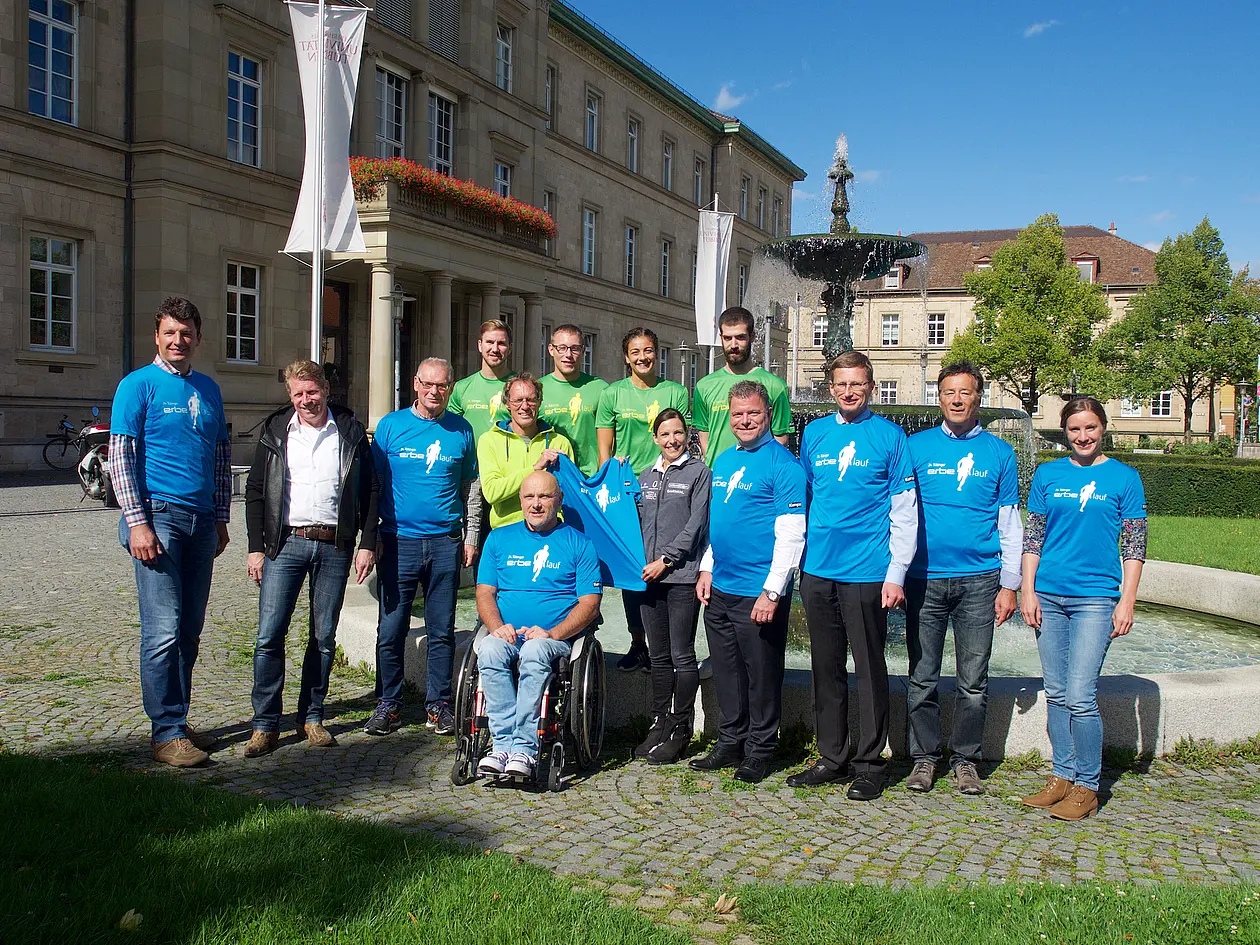 Gruppenfoto des Organisationsteams des Erbe-Laufs. Von links nach rechts: Dr. Christopher Baron - Berufsgenossenschaftliche Unfallklinik; Marc Oßwald – Projektleitung; Rainer Kaltenmark – Fachabteilung Ordnung und Gewerbe, Stadt Tübingen; Dieter Baumann – Projektleitung; Karl-Heinz Bauknecht  - Berufsgenossenschaftliche Unfallklinik; Läuferin Sabrina Mockenhaupt; Christian O. Erbe – Elektromedizin GmbH; Dr. Andreas Rothfuß; Andreas Dietrich – Projektleitung; Judith Deprins – künftige Projektleiterin. In grünen Trikots, zweite Reihe: Sportstudierende aus dem Organisationsteam des Erbe-Laufs. Foto: Friedhelm Albrecht/Universität Tübingen