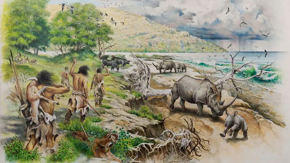 An artistic reconstruction of a coastal landscape with trees. In the foreground are people with spears and rhinos. In the background are rain clouds and birds in the sky. 