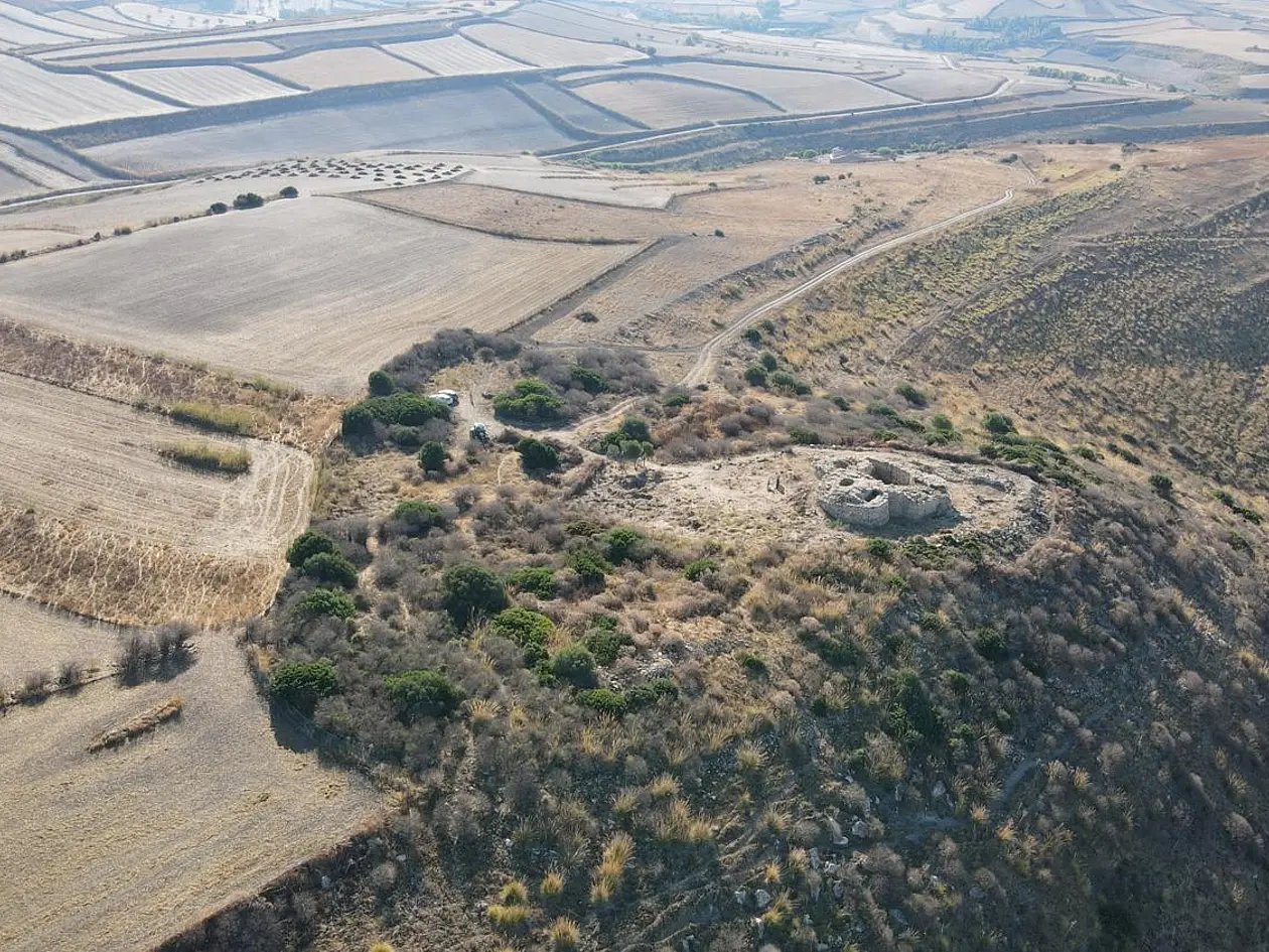Foto einer archäologischen Fundstätte auf einem Hügel in karger Landschaft