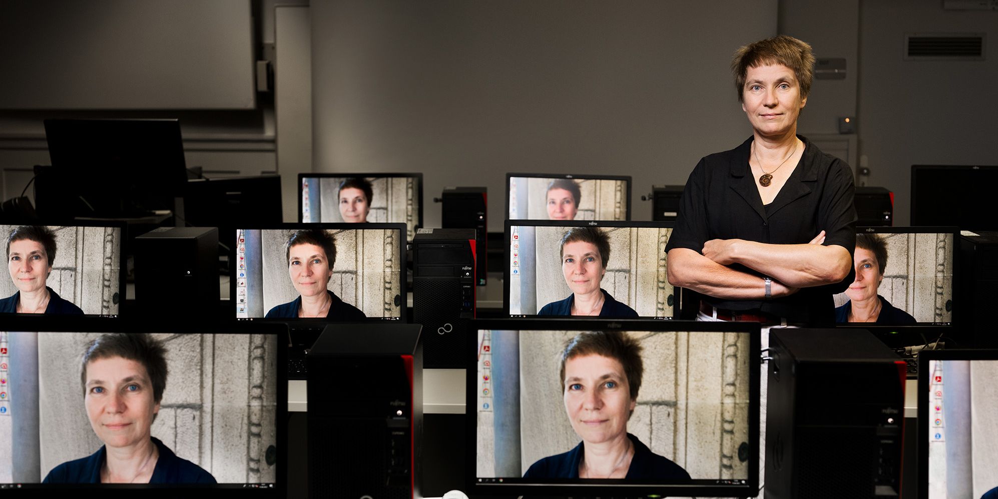 Photo of von Dr. Jessica Heesen, as well reflected on several screens.