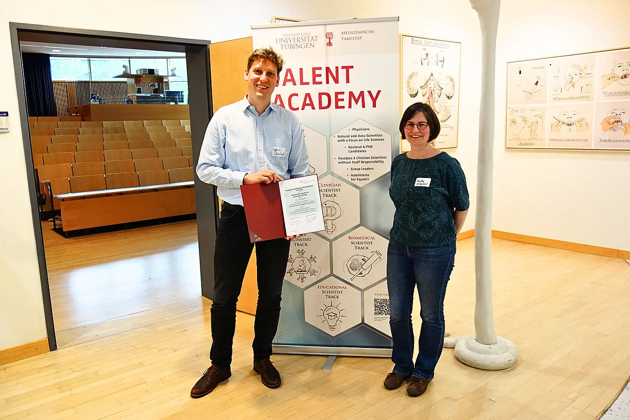 Dr. Lukas Beichert bei der Preisverleihung. Rechts Dr. Annika Erbacher vom Clinician Scientist Office der Medizinischen Fakultät. 