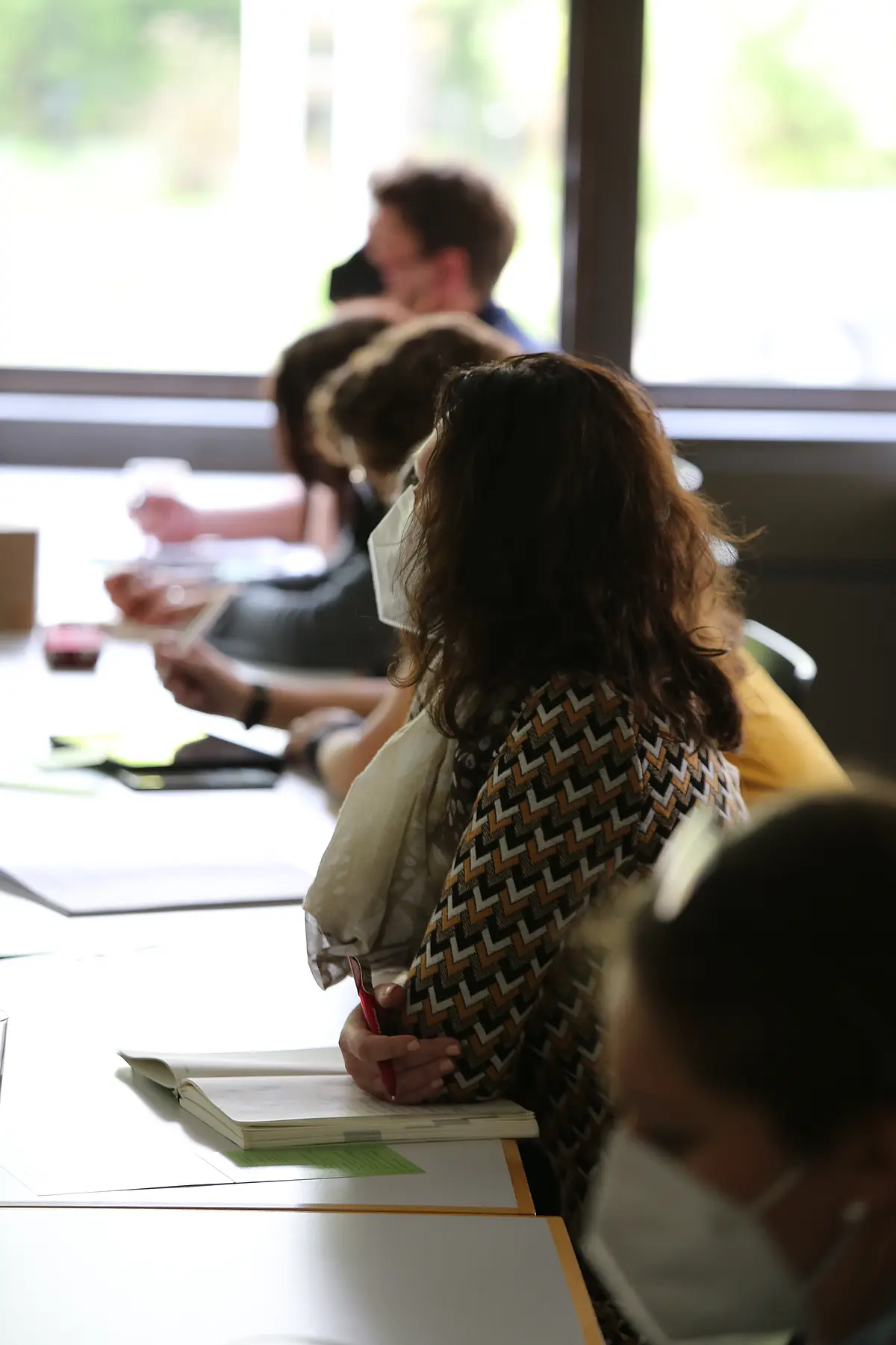 Workshopteilnehmer:innen beim Hören eines Vortrags