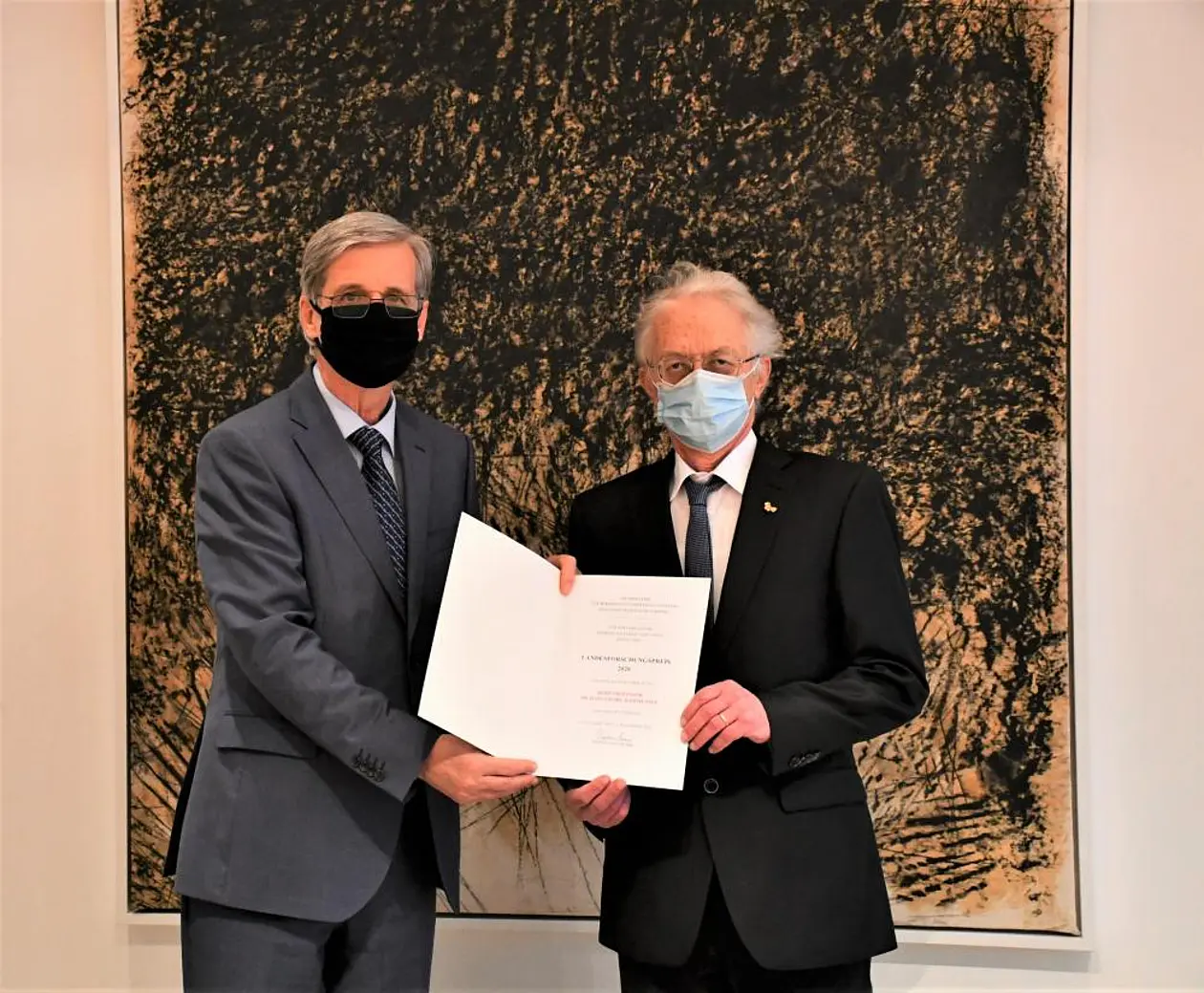 Prof. Dr. Bernd Engler und Prof. Dr. Hans-Georg Rammensee zeigen die Urkunde des Landesforschungspreises