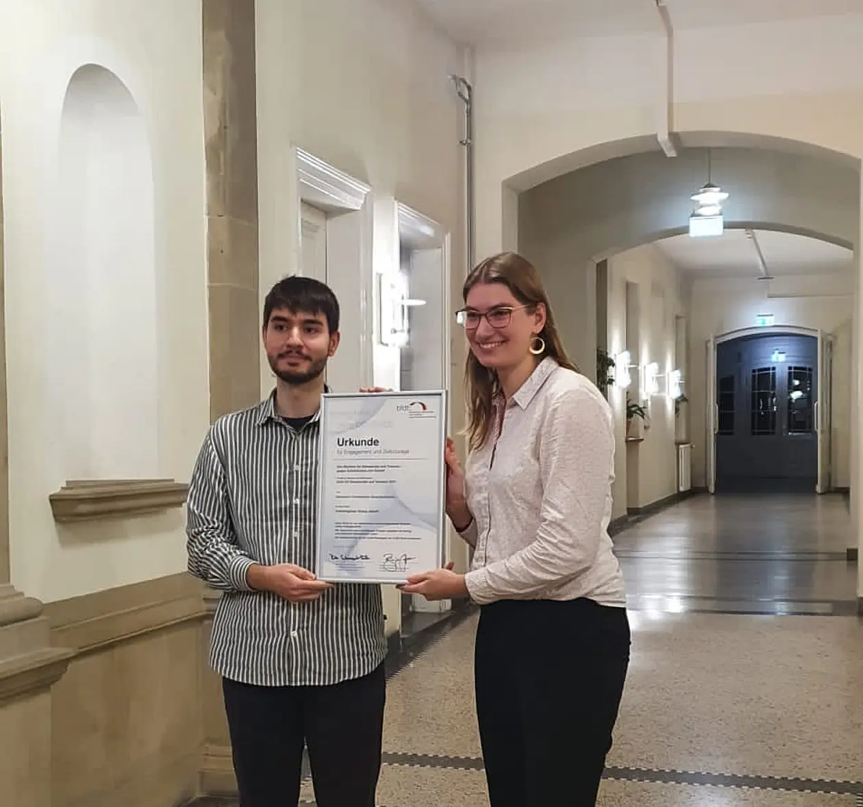 Hakan Kavak und Mirjam Wien als studentische Organisatoren des Gesprächskreises mit der Preisurkunde