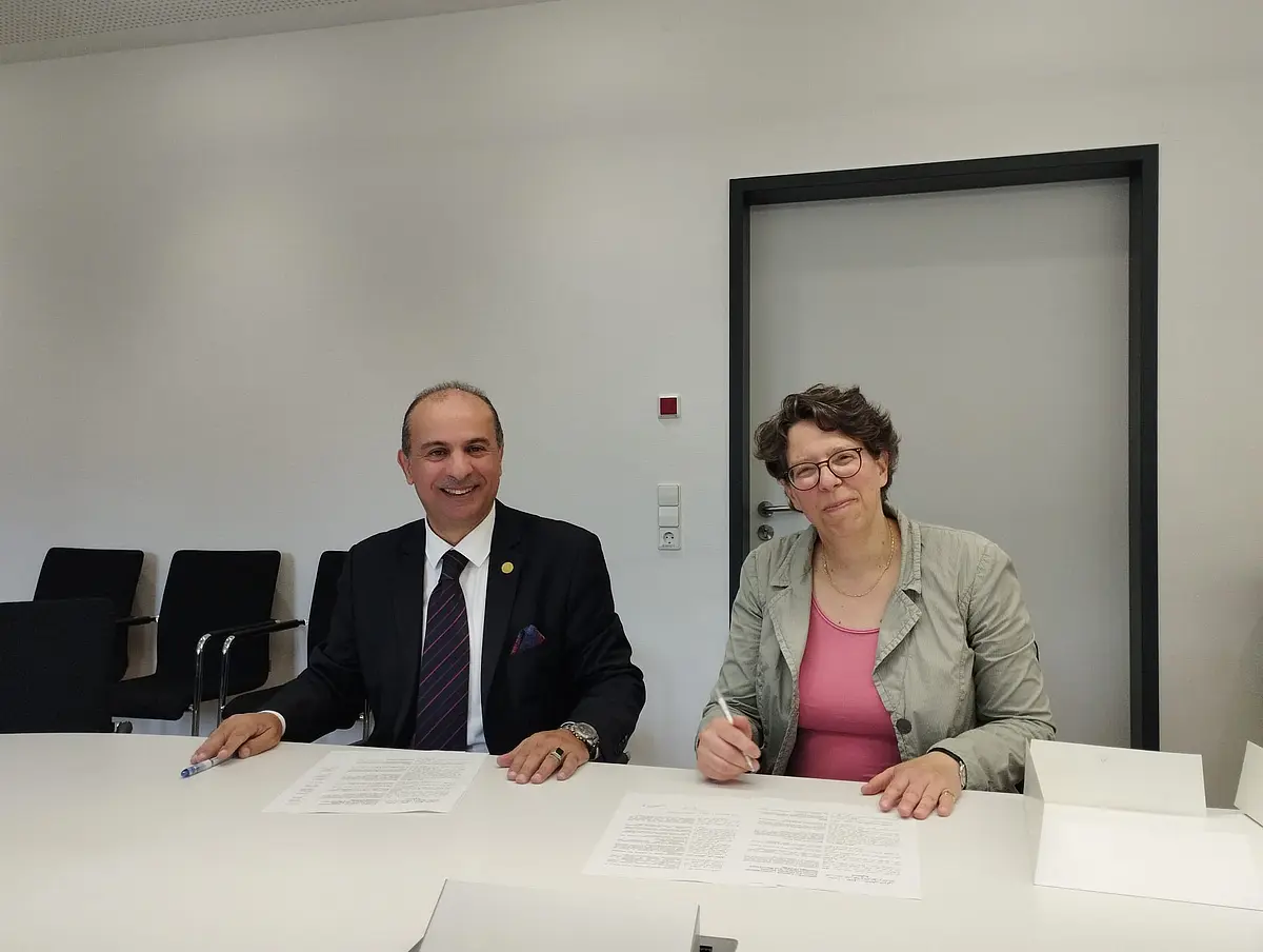 [Translate to English:] Das Bild zeigt SE Dr. Mohammad Issa al-Edwan und Prof. Dr. Regula Forster bei der Unterzeichnung der Absichtserklärung für künftige Kooperation.