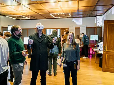 BesucherInnen bei der Science Fair, einer mit VR-Brille