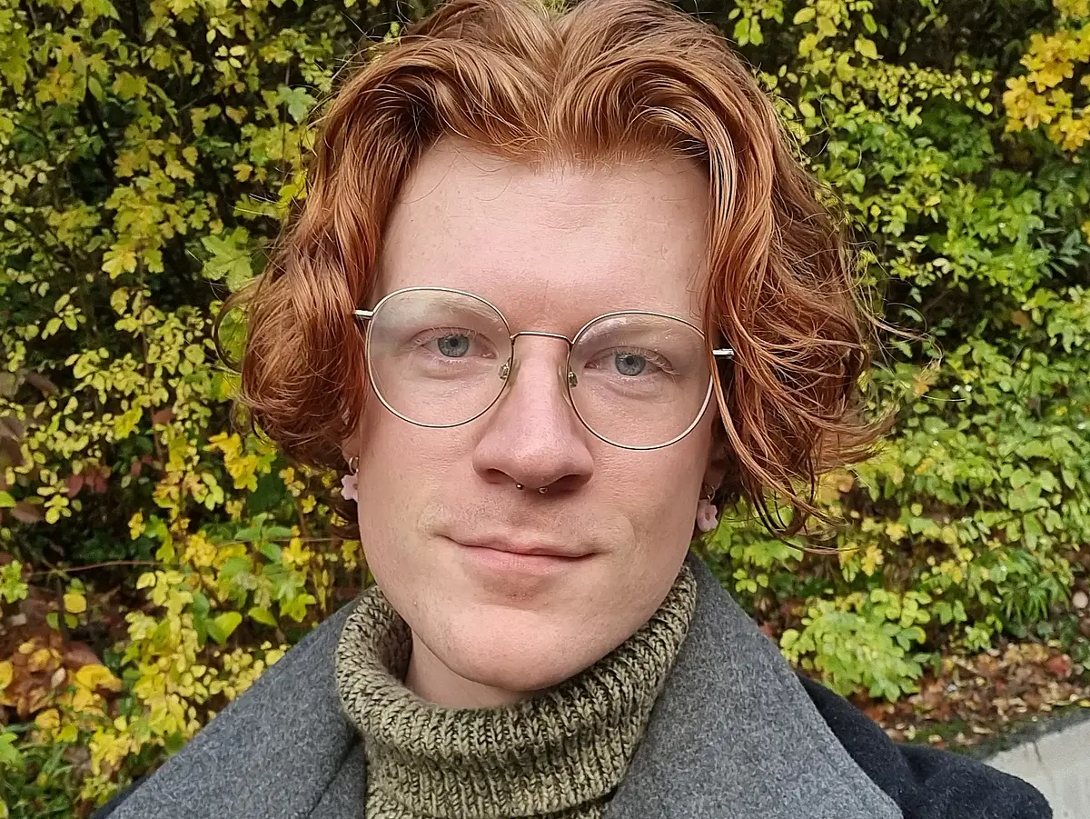 Die Fotographie zeigt Tyler Houston, der in die Kamera lächelt.