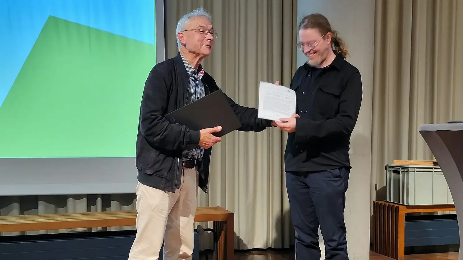 Dr. Klaus Rehfeld (links) und Dr. Chris Baumann bei der Überreichung der Urkunde.