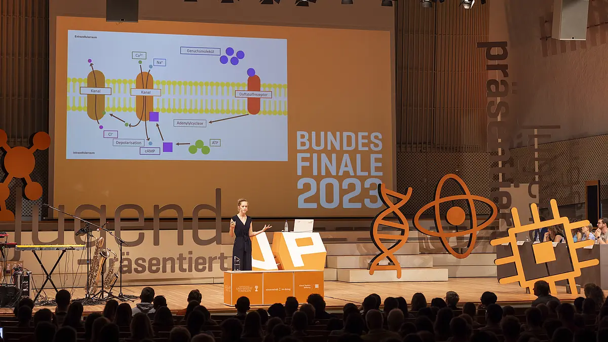 Junge Frau hält eine Präsentation auf einer Bühne