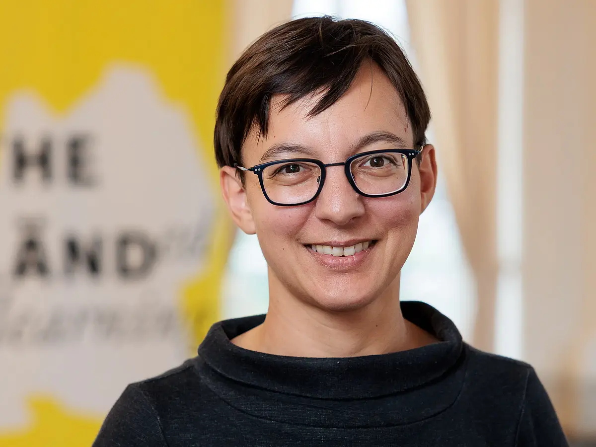 Portrait shot of Prof. Dr. Kira Rehfeld who is smiling into the camera.