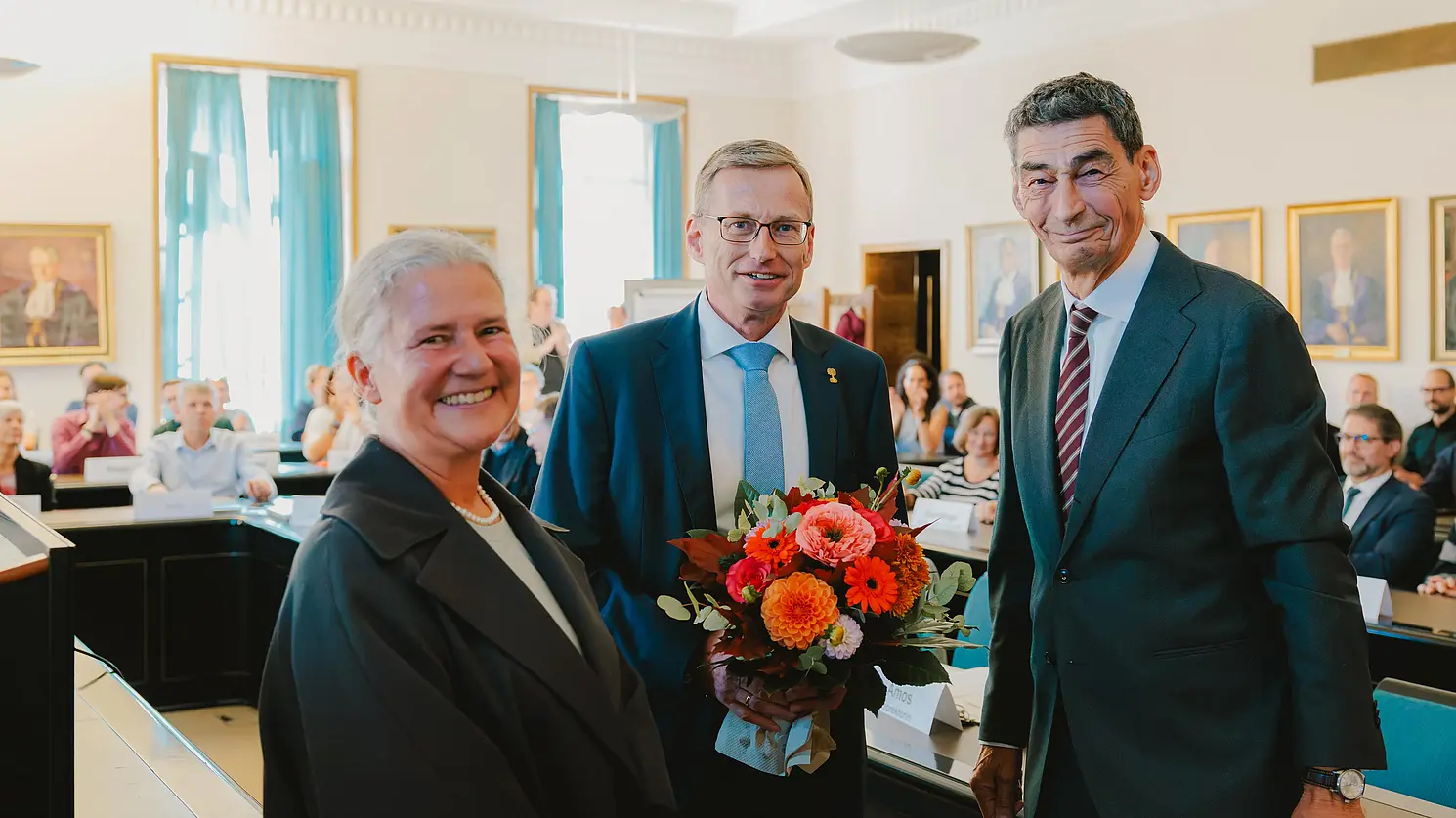 Rektorin Karla Pollmann (links) und Bernhard Sibold (rechts), gratulieren Kanzler Andreas Rothfuß (Mitte) zur Wiederwahl.  