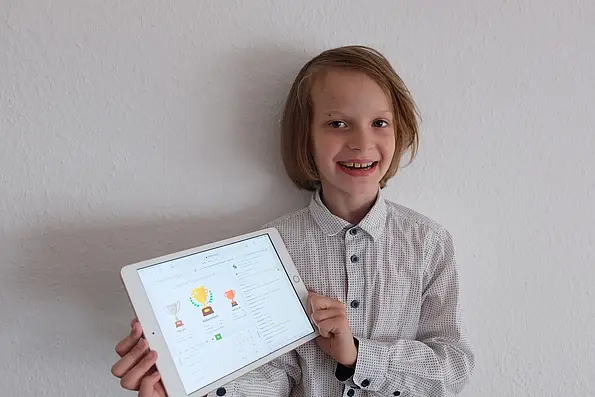 Foto mit dem Sieger des Online-Schachturniers Robert mit einem Tablet in der Hand.