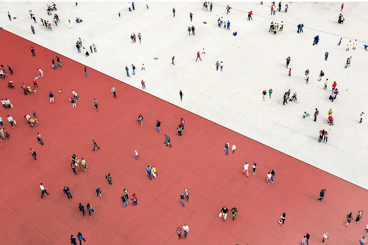 A crowd is divided by a line between a white and a red area.