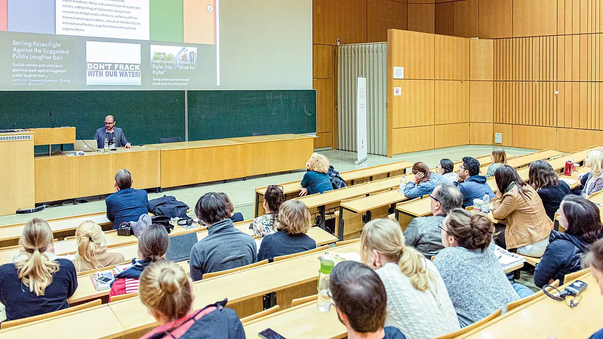Menschen sitzen im größten Vorlesungssaal des Tübinger Kupferbaus und hören einen Vortrag. Studium Generale