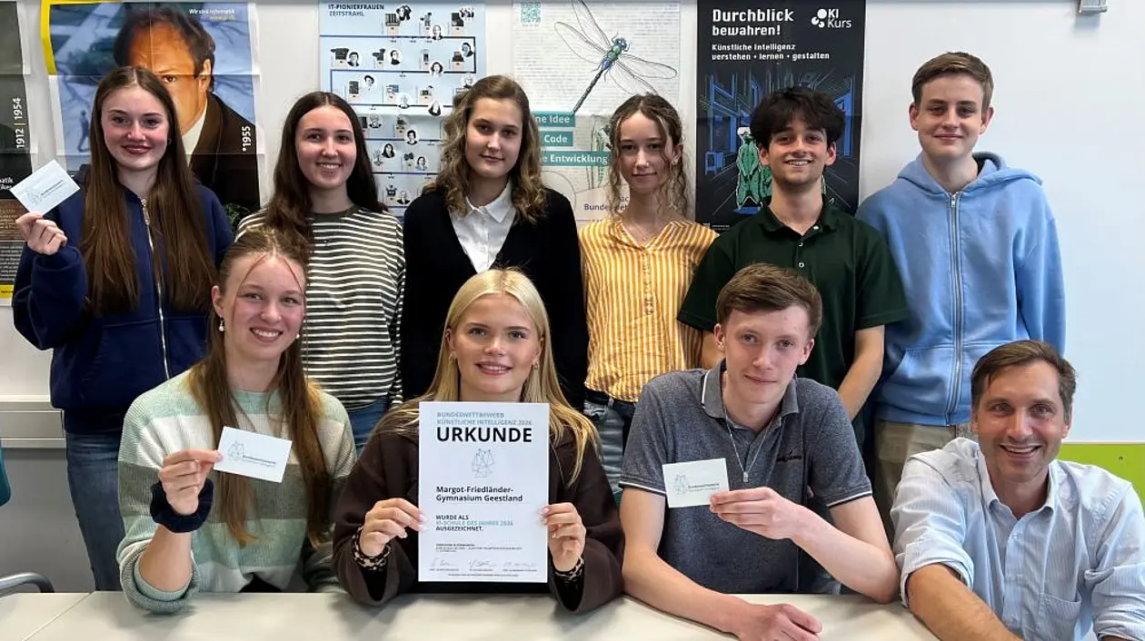 Neun Schülerinnen und Schüler in zwei Reihen hintereinander mit ihrem Lehrer. In der Mitte zeigt eine Schülerin die Urkunde.