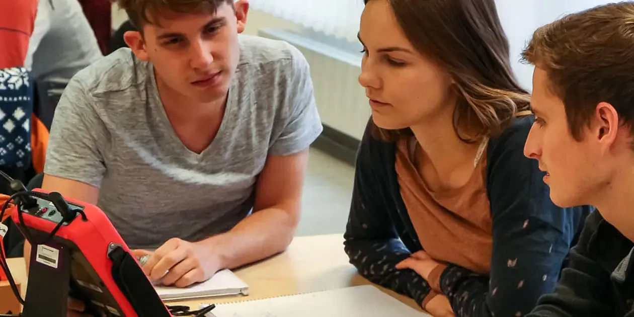 Studierende untersuchen elektrische Schaltkreise mit einem Oszilloskop.
