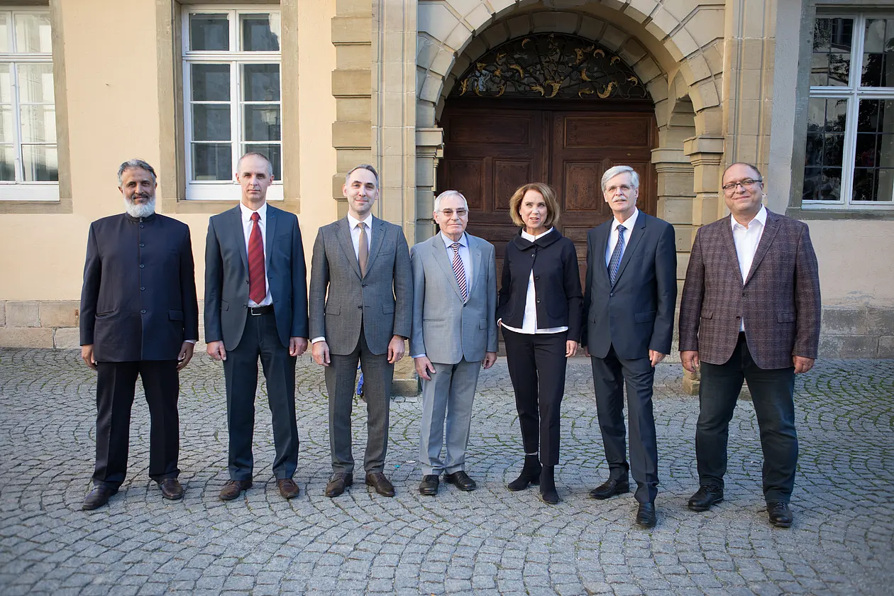 Gruppenbild vor dem Gebäude "Alte Aula" mit Dr. Abdulrahman Al Salmi (Ministerium für Stiftungen und religiöse Angelegenheiten des Oman), Professor Dr. hfz. Aid Smajić (Faculty of Islamic Studies der Universität Sarajevo), Gürcan Mert (Vorsitzender des ZITh-Beirats), Professor Dr. Stefan Schreiner (Universität Tübingen), Staatssekretärin Petra Olschowski MdL (Ministerium für Wissenschaft, Forschung und Kunst Baden-Württemberg), Professor Bernd Engler (Rektor der Universität Tübingen), Professor Dr. Erdal Toprakyaran (Direktor des Zentrums für Islamische Theologie)